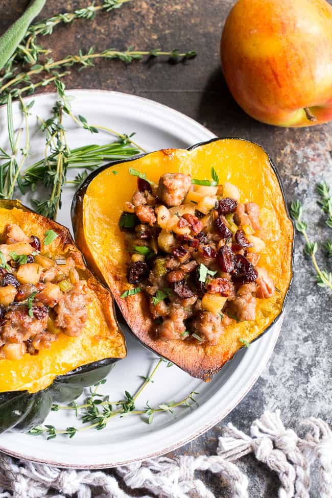 This Roasted Stuffed Acorn Squash is filled with all your favorites - sausage, apples, cranberries, onions, celery and savory herbs. The stuffing is packed with savory/sweet flavors and the perfect addition to a holiday gathering, or for any meal!  Paleo, gluten free, Whole30 compliant.