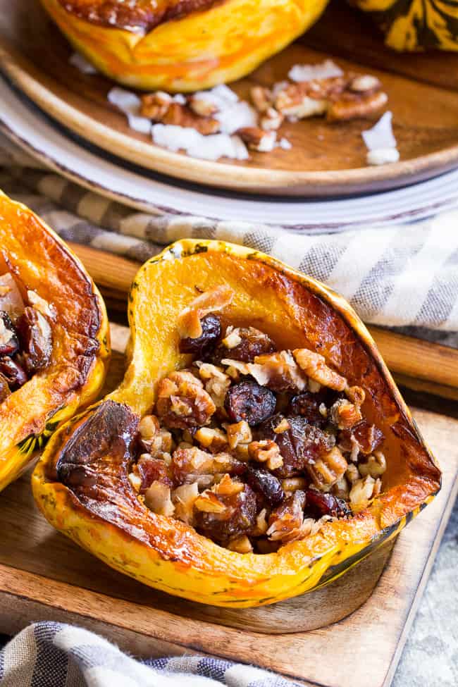 Winter squash is roasted, filled with a sweet "candy" mixture, drizzled with maple and roasted again to combine flavors.  This paleo and vegan roasted squash recipe is perfect as a sweet side dish for the holidays, or a dessert!