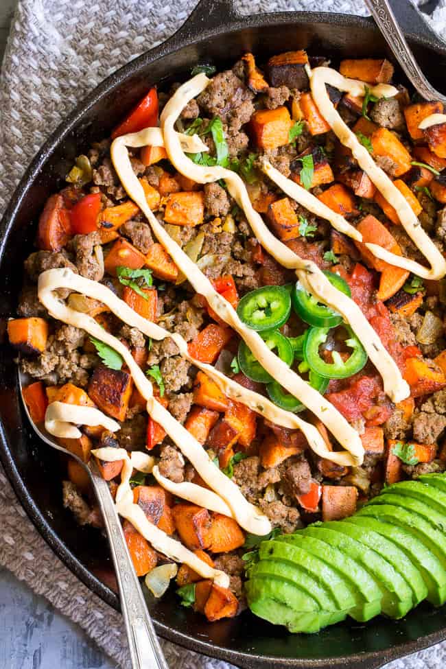 This taco sweet potato skillet is loaded with spicy ground beef, peppers and onions, jalapeños, salsa, avocado and chipotle ranch plus any and all of your favorite toppings!  Try a crispy fried egg and crumbled bacon for brunch heaven!  Paleo and Whole30 compliant.