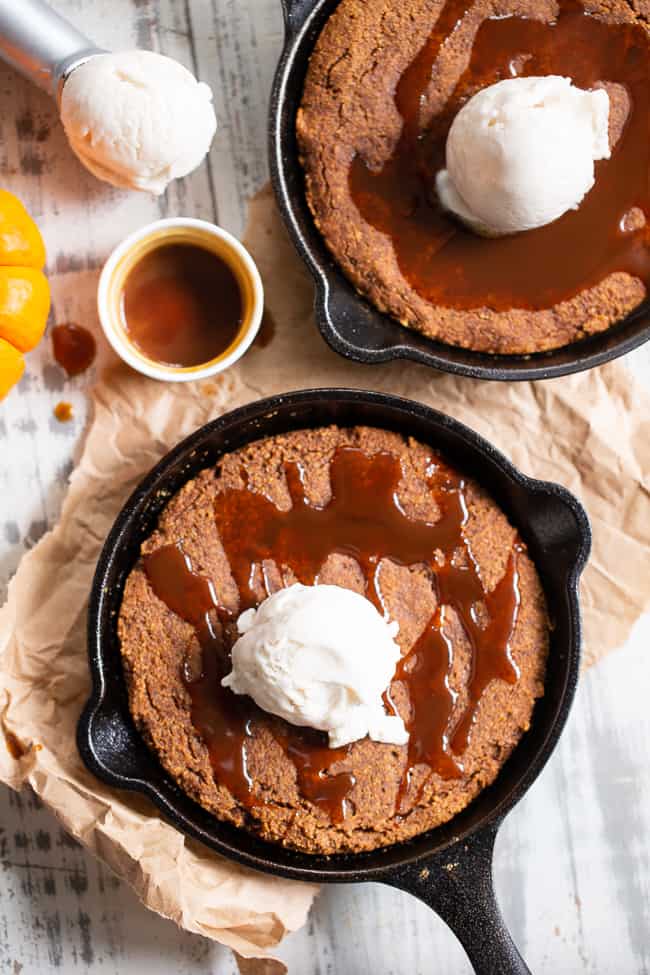 This fudgy pumpkin snickerdoodle skillet cookie is loaded with pumpkin spice and cinnamon, drizzled with dairy-free salted caramel sauce and topped with coconut vanilla ice cream.  This rich paleo dessert is perfect for fall and the holiday season!  Kid approved, paleo, dairy-free, grain-free.