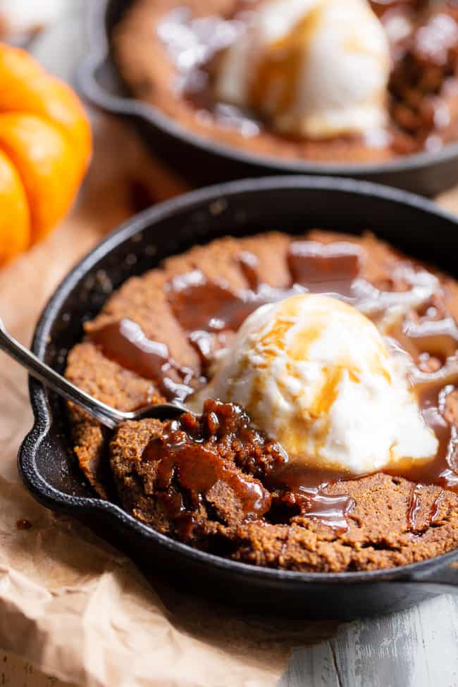 This fudgy pumpkin snickerdoodle skillet cookie is loaded with pumpkin spice and cinnamon, drizzled with dairy-free salted caramel sauce and topped with coconut vanilla ice cream.  This rich paleo dessert is perfect for fall and the holiday season!  Kid approved, paleo, dairy-free, grain-free.