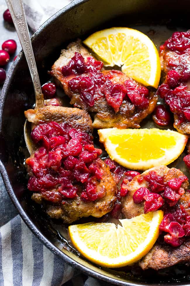 We take crisp, savory spiced chicken thighs and a healthy, refined sugar free orange cranberry sauce and bake them together to delicious perfection!  This Paleo Orange Cranberry Chicken is easy to make, gluten-free, dairy-free, and has a Whole30 friendly option.