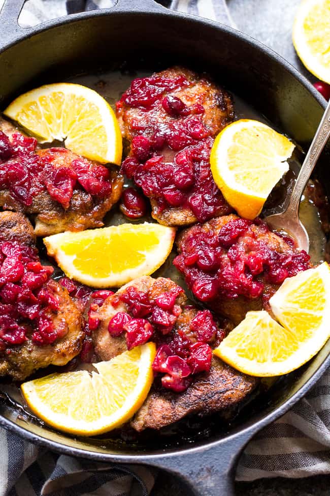We take crisp, savory spiced chicken thighs and a healthy, refined sugar free orange cranberry sauce and bake them together to delicious perfection!  This Paleo Orange Cranberry Chicken is easy to make, gluten-free, dairy-free, and has a Whole30 friendly option.