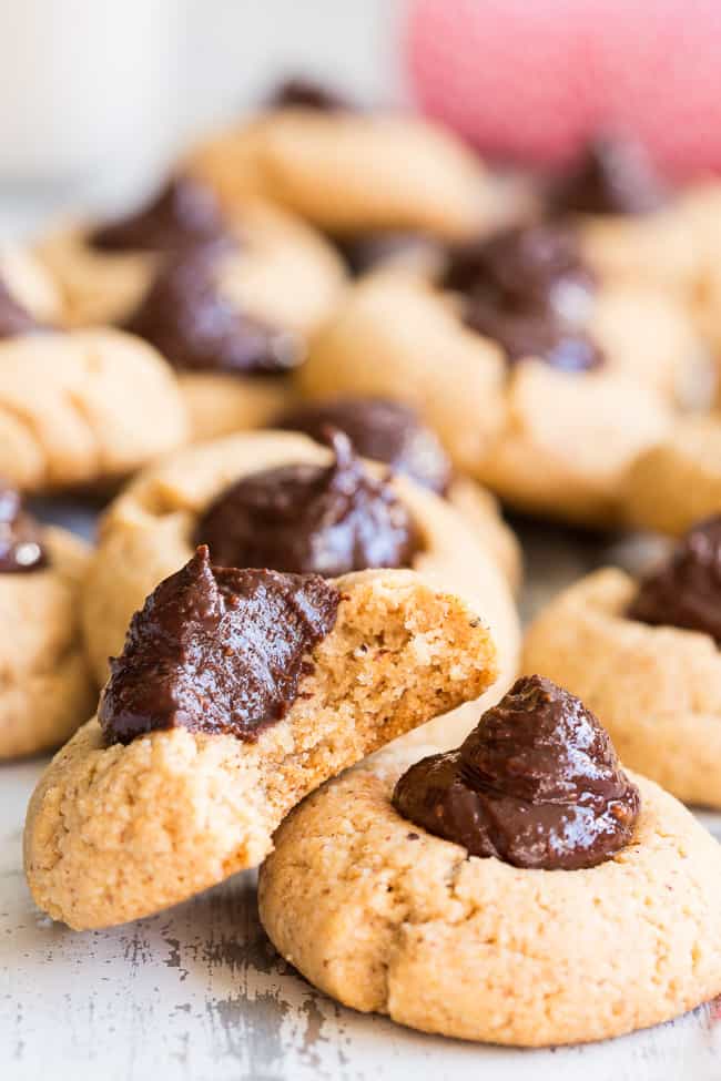 tan colored cookies with fudgy chocolate swirled centers scattered and stacked