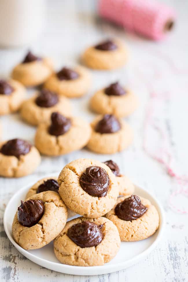 a plate of almond butter cookies with chocolate swirl centers and more cookies in the background