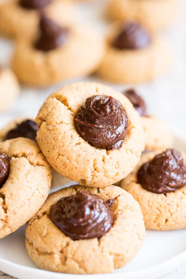 tan cookies with a chocolate swirl center stacked on parchment