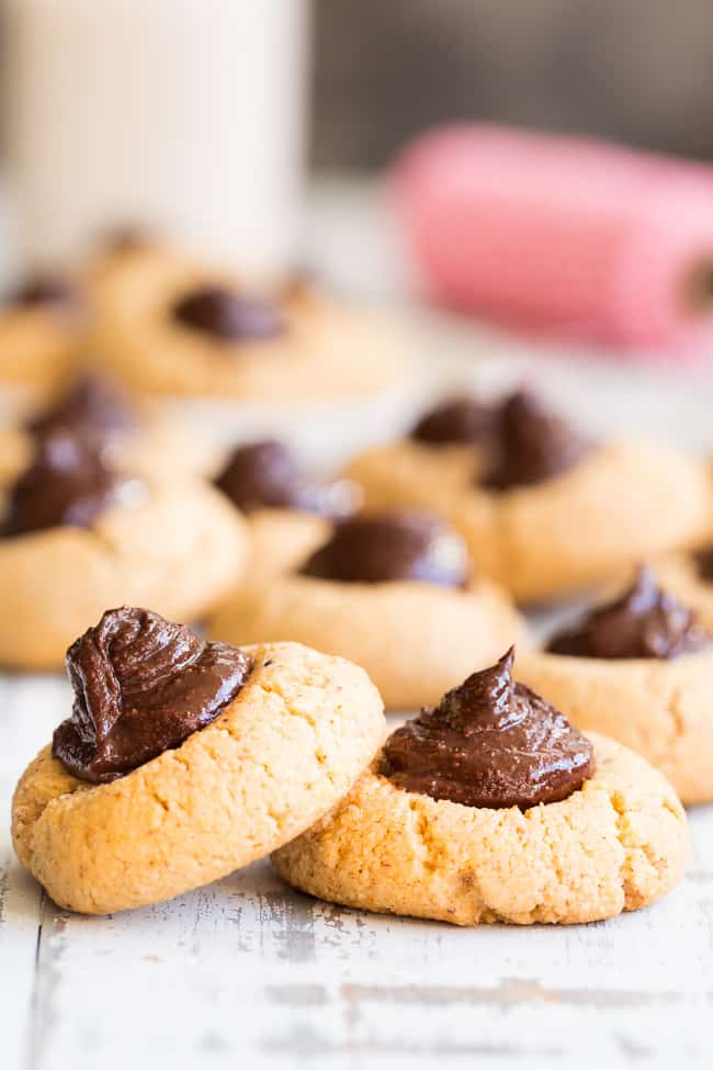 two round light brown cookies with fudgy brown chocolate mounds in the centers