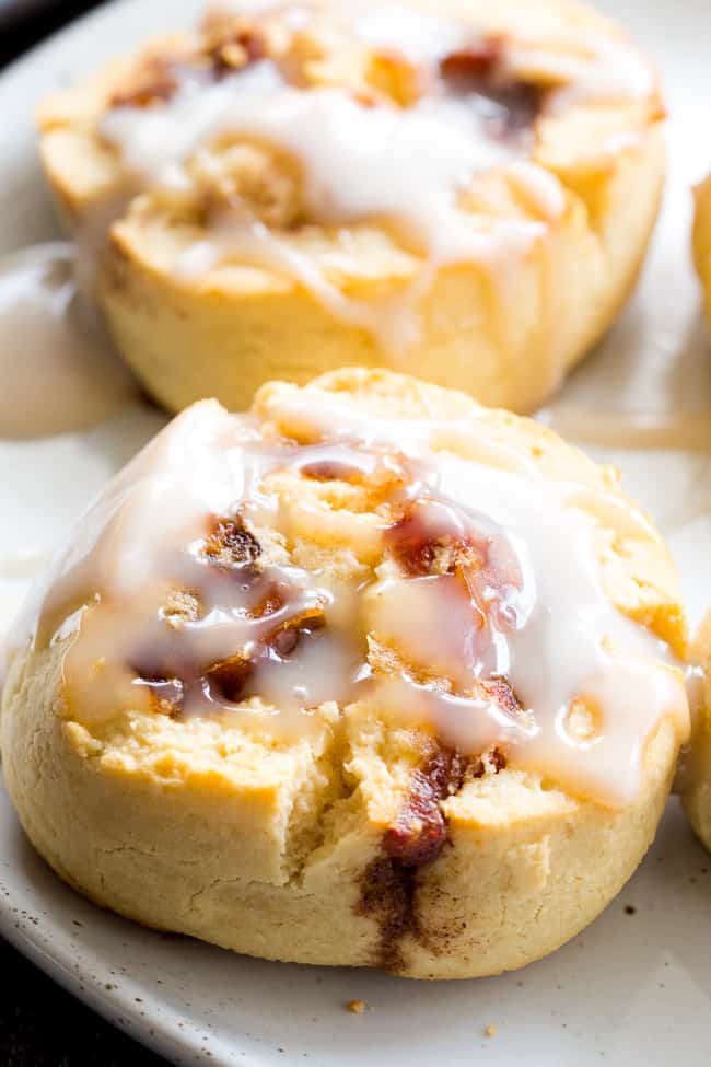 two cinnamon rolls drizzled with a white frosting glaze 