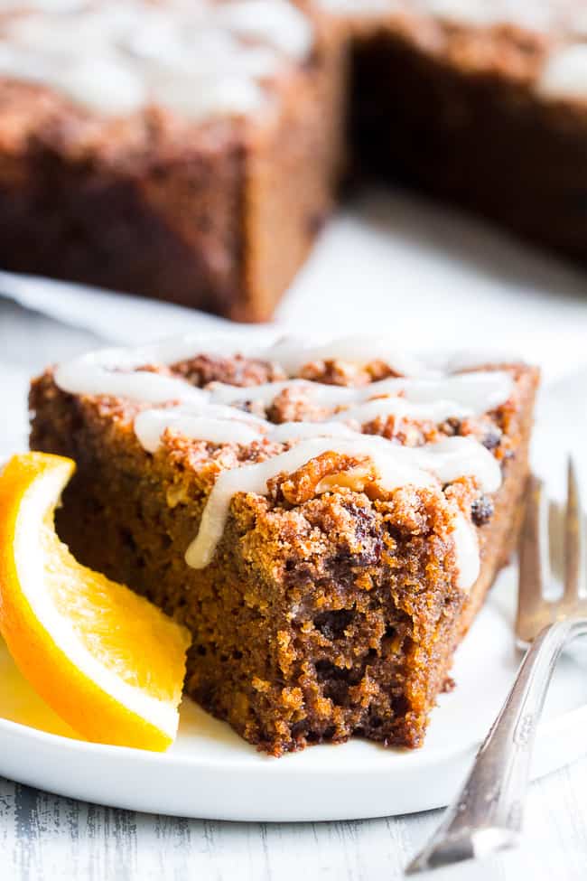 a triangular slice of brown cofee cake with white icing drizzled over top