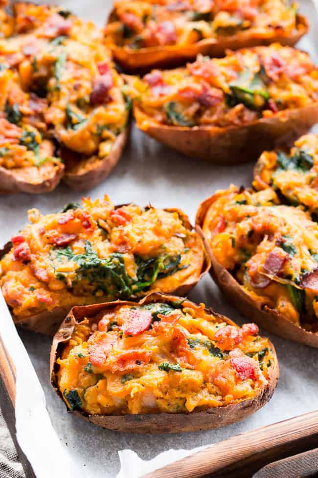 These twice baked sweet potatoes can be served as a healthy meal or side dish - your choice!  They're packed with a savory mixture of caramelized onions, spinach and bacon and baked to perfection.  They're family approved, Paleo, Whole30 compliant, and dairy-free.  