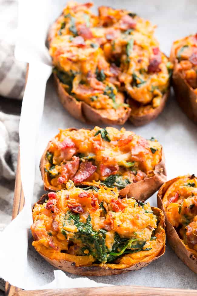 These twice baked sweet potatoes can be served as a healthy meal or side dish - your choice!  They're packed with a savory mixture of caramelized onions, spinach and bacon and baked to perfection.  They're family approved, Paleo, Whole30 compliant, and dairy-free.  