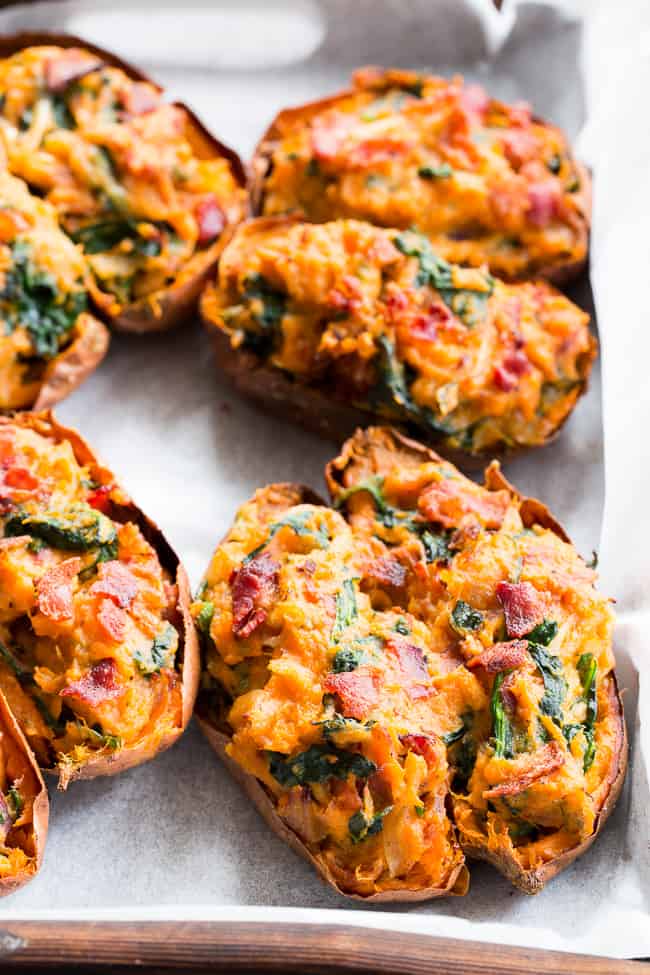 These twice baked sweet potatoes can be served as a healthy meal or side dish - your choice!  They're packed with a savory mixture of caramelized onions, spinach and bacon and baked to perfection.  They're family approved, Paleo, Whole30 compliant, and dairy-free.  