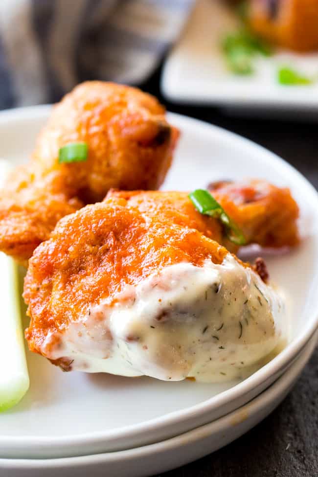 These crispy baked buffalo chicken wings are easy to make, healthy, and ridiculously tasty!   They're  paleo and Whole30 compliant and perfect with Whole30 homemade ranch dip. Perfect as a healthy appetizer, Super Bowl snack or with a salad for dinner! #Whole30 #Paleo 