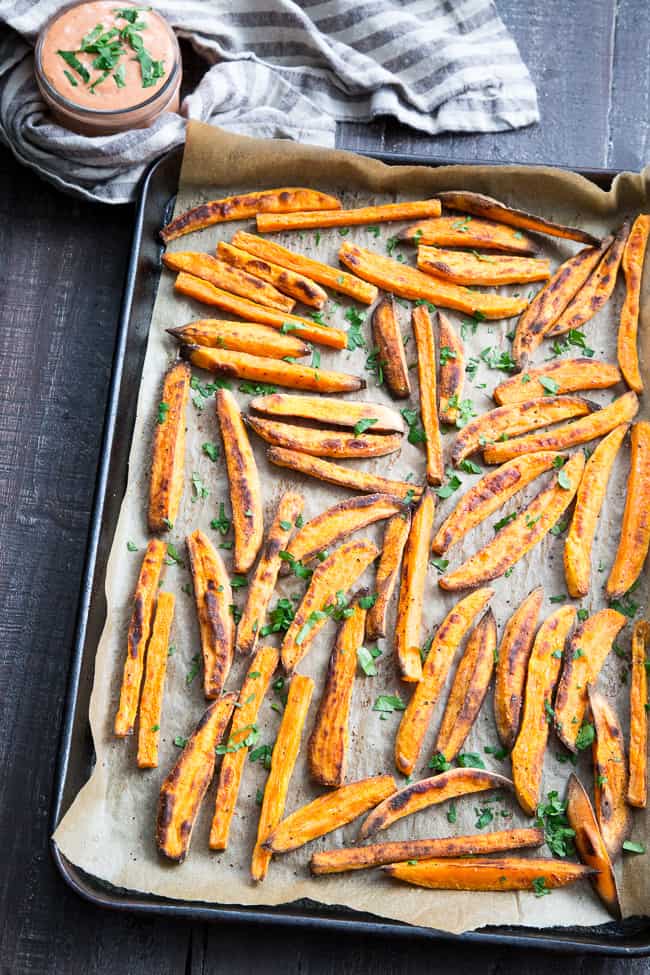 Crispy baked paleo and Whole30 compliant sweet potato fries are not only possible, but easy to make, too!  Served here with an insanely tasty, Whole30 compliant BBQ ranch dip that you'll want to put on everything.  Kid approved, great for a fun snack, side dish, or appetizer any time!