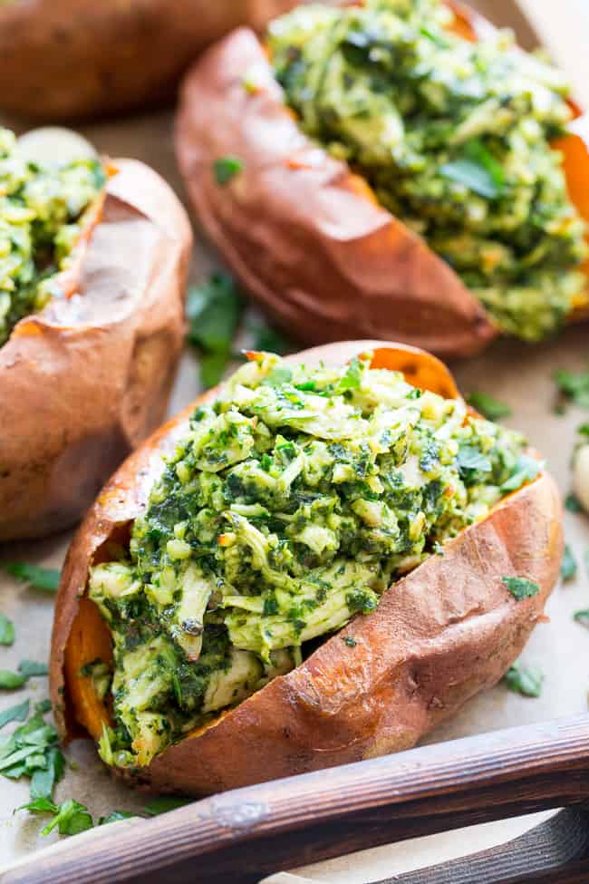 These chicken pesto stuffed sweet potatoes are seriously tasty, filling and easy to make!  A paleo and Whole30 compliant pesto is mixed with shredded chicken and tops perfectly baked sweet potatoes.  Great to make ahead of time and the leftovers save well!