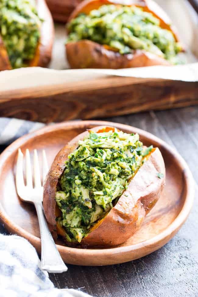 These chicken pesto stuffed sweet potatoes are seriously tasty, filling and easy to make!  A paleo and Whole30 compliant pesto is mixed with shredded chicken and tops perfectly baked sweet potatoes.  Great to make ahead of time and the leftovers save well!