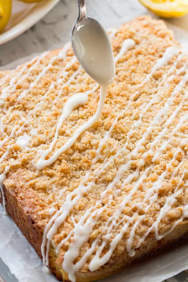 This amazing paleo lemon crumb cake is deliciously sweet/tart and bursting with fresh lemon flavor!  It starts with a  perfectly moist lemon cake layer, topped with lemon curd, piled with crumb topping and drizzled with lemon glaze.  It's gluten-free, dairy-free, paleo will become a favorite dessert with the first bite!