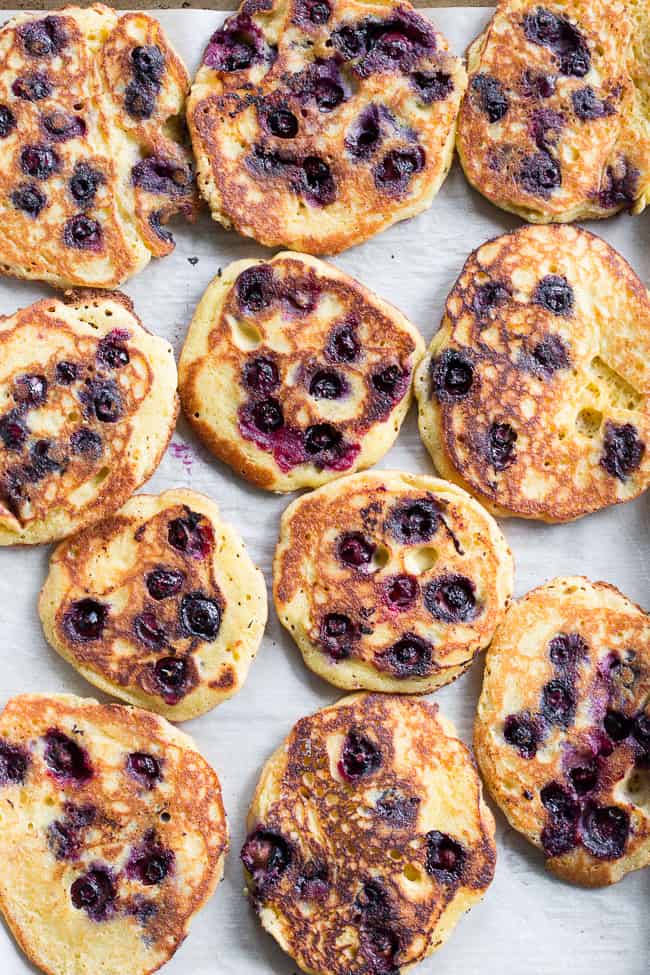 These paleo lemon blueberry pancakes are perfectly sweet and fluffy and a breeze to make!  They're packed with juicy blueberries and fresh lemon juice for a weekend breakfast or brunch that's healthy, delicious and even kid approved.  Gluten free, dairy free, grain free and refined-sugar free.