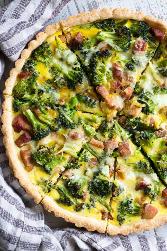 This grain free and paleo savory tart begins with the perfect paleo crust loaded with chopped broccoli and sugar-free ham, plus a creamy egg mixture with a dairy-free option.  This amazing savory tart is a family favorite, kid approved and perfect for brunch or as a make ahead breakfast!