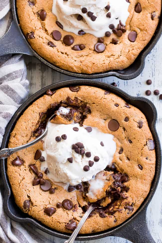 This fudgy paleo chocolate chip skillet cookie is loaded with good stuff!  Almond butter and coconut oil give it chewy moist and fudgy texture and it's sweetened with raw honey and unrefined coconut sugar.  A combination of coconut and arrowroot flour keep it grain free and gluten free!  It's packed with dark chocolate chips and perfect topped with a big scoop of coconut vanilla ice cream.