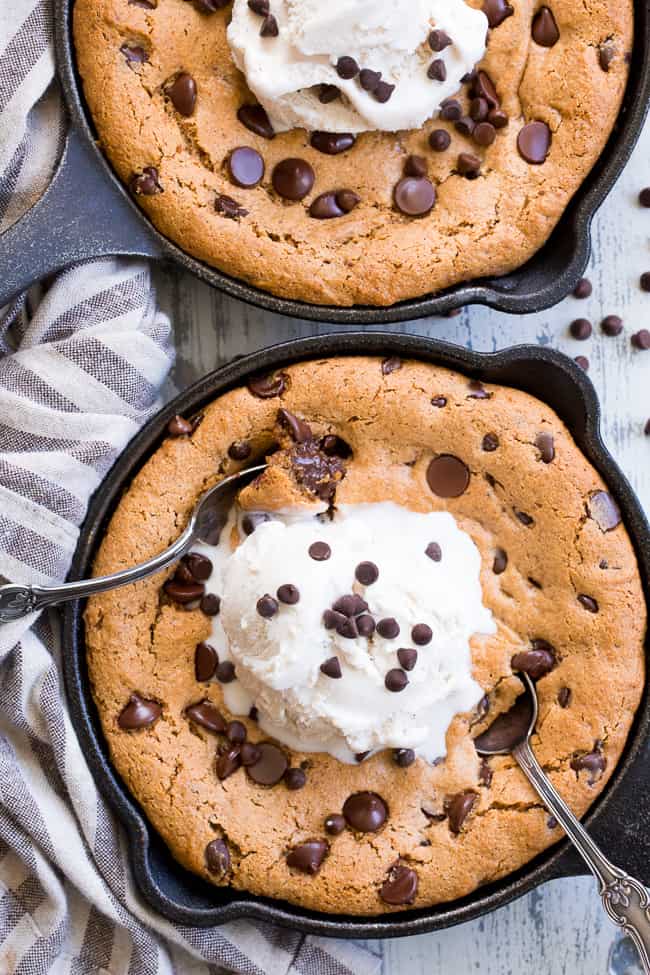 This fudgy paleo chocolate chip skillet cookie is loaded with good stuff!  Almond butter and coconut oil give it chewy moist and fudgy texture and it's sweetened with raw honey and unrefined coconut sugar.  A combination of coconut and arrowroot flour keep it grain free and gluten free!  It's packed with dark chocolate chips and perfect topped with a big scoop of coconut vanilla ice cream.