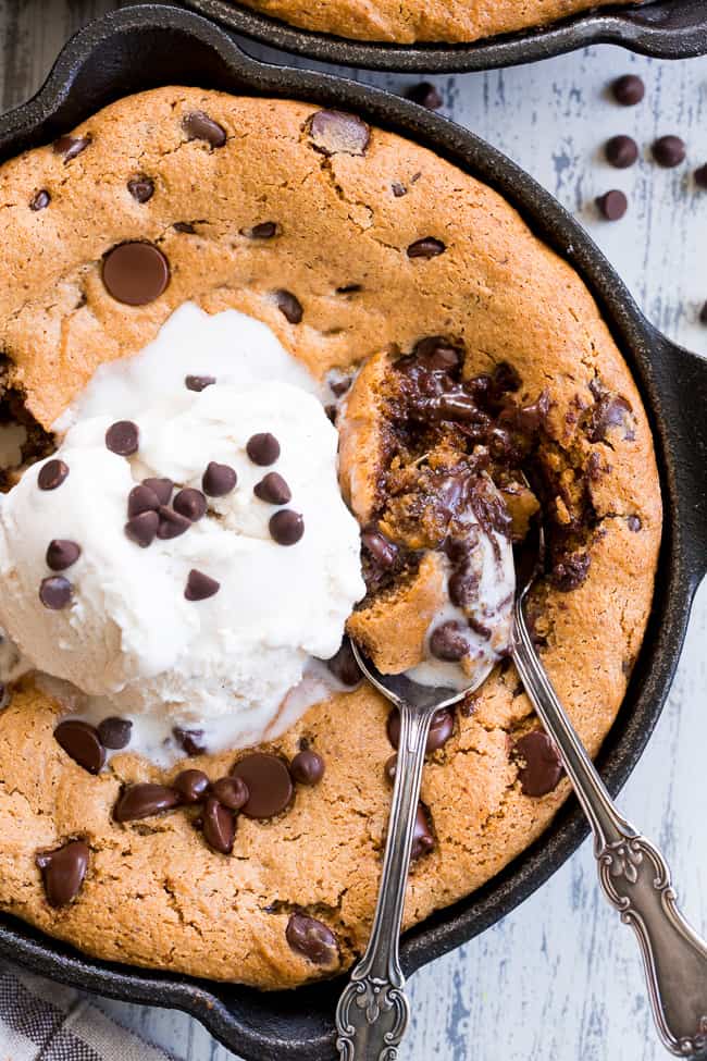 This fudgy paleo chocolate chip skillet cookie is loaded with good stuff!  Almond butter and coconut oil give it chewy moist and fudgy texture and it's sweetened with raw honey and unrefined coconut sugar.  A combination of coconut and arrowroot flour keep it grain free and gluten free!  It's packed with dark chocolate chips and perfect topped with a big scoop of coconut vanilla ice cream.