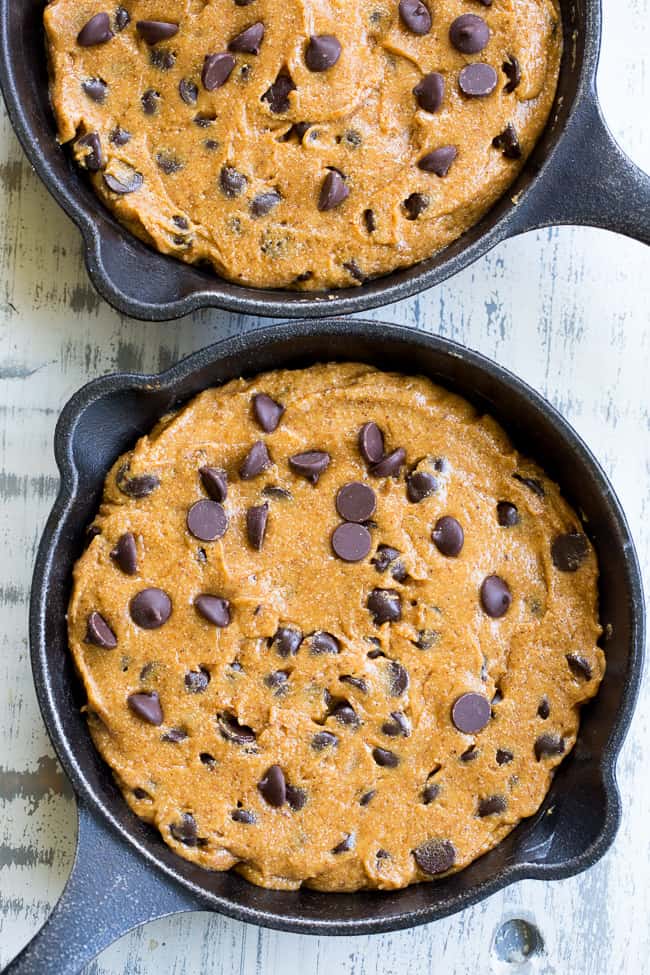 This fudgy paleo chocolate chip skillet cookie is loaded with good stuff!  Almond butter and coconut oil give it chewy moist and fudgy texture and it's sweetened with raw honey and unrefined coconut sugar.  A combination of coconut and arrowroot flour keep it grain free and gluten free!  It's packed with dark chocolate chips and perfect topped with a big scoop of coconut vanilla ice cream.