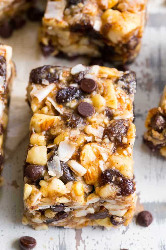 Chewy, crunchy, sweet and salty, these grain free and paleo no bake granola bars are going to become your favorite with the first bite!  They're loaded with raisins and mini chocolate chips, coconut flakes and nuts, sweetened with raw honey and packed with healthy fats.  Kid approved, gluten-free, dairy-free, grain free and addicting! 