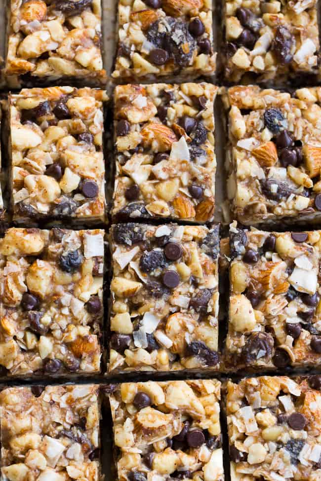 Chewy, crunchy, sweet and salty, these grain free and paleo no bake granola bars are going to become your favorite with the first bite!  They're loaded with raisins and mini chocolate chips, coconut flakes and nuts, sweetened with raw honey and packed with healthy fats.  Kid approved, gluten-free, dairy-free, grain free and addicting! 