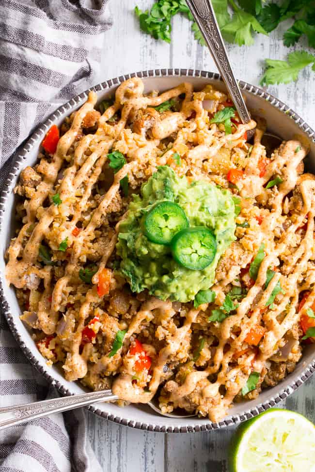 This Mexican Cauliflower Fried Rice is packed with veggies, protein, and lots of flavor and spice!  It's topped with an easy guacamole and chipotle ranch sauce for a tasty, filling meal that's Paleo, Whole30 compliant and keto friendly.