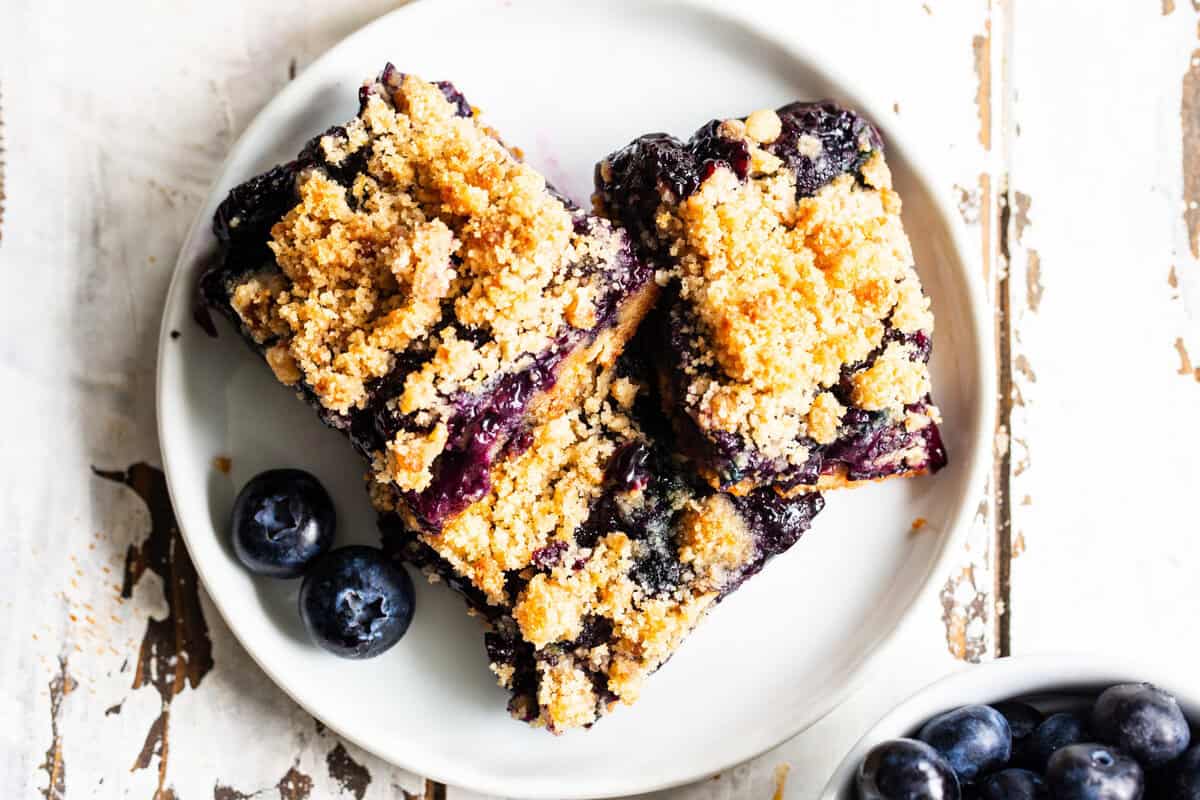 gluten free blueberry crumble bars with almond flour crust and jammy filling on a plate