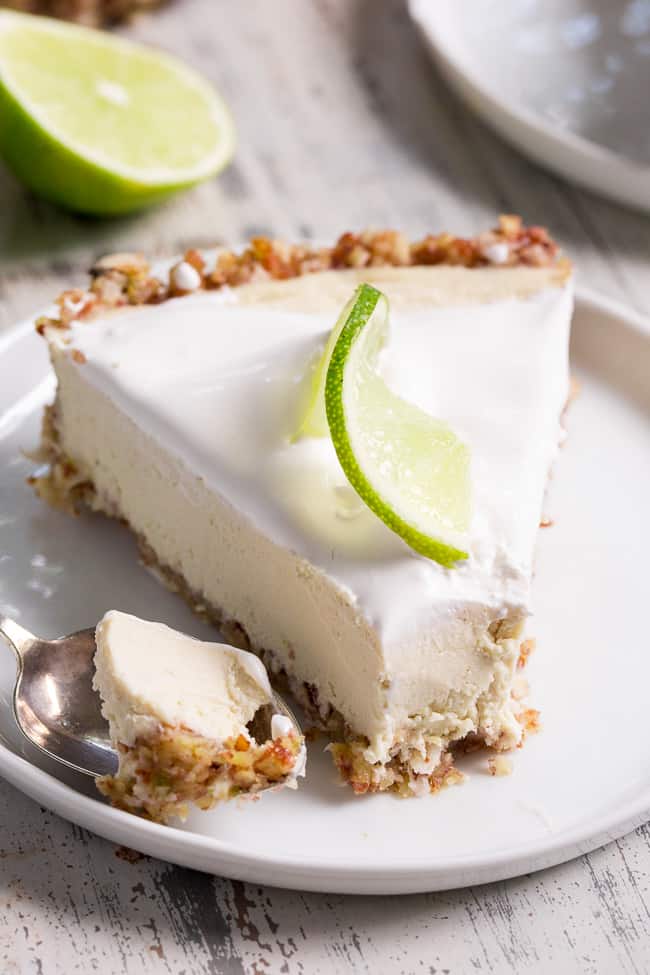 This key lime paleo and vegan cheesecake tart is insanely creamy, perfectly sweet/tart and couldn't be easier to make!  The no-bake dairy-free, cashew-based filling blends up quickly and chills to perfection in a simple coconut pecan crust.   It's family approved and sure to become a favorite special occasion dessert!