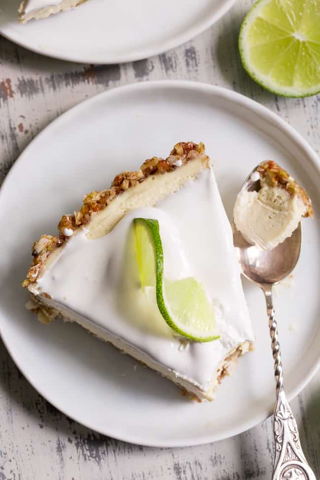 This key lime paleo and vegan cheesecake tart is insanely creamy, perfectly sweet/tart and couldn't be easier to make!  The no-bake dairy-free, cashew-based filling blends up quickly and chills to perfection in a simple coconut pecan crust.   It's family approved and sure to become a favorite special occasion dessert!