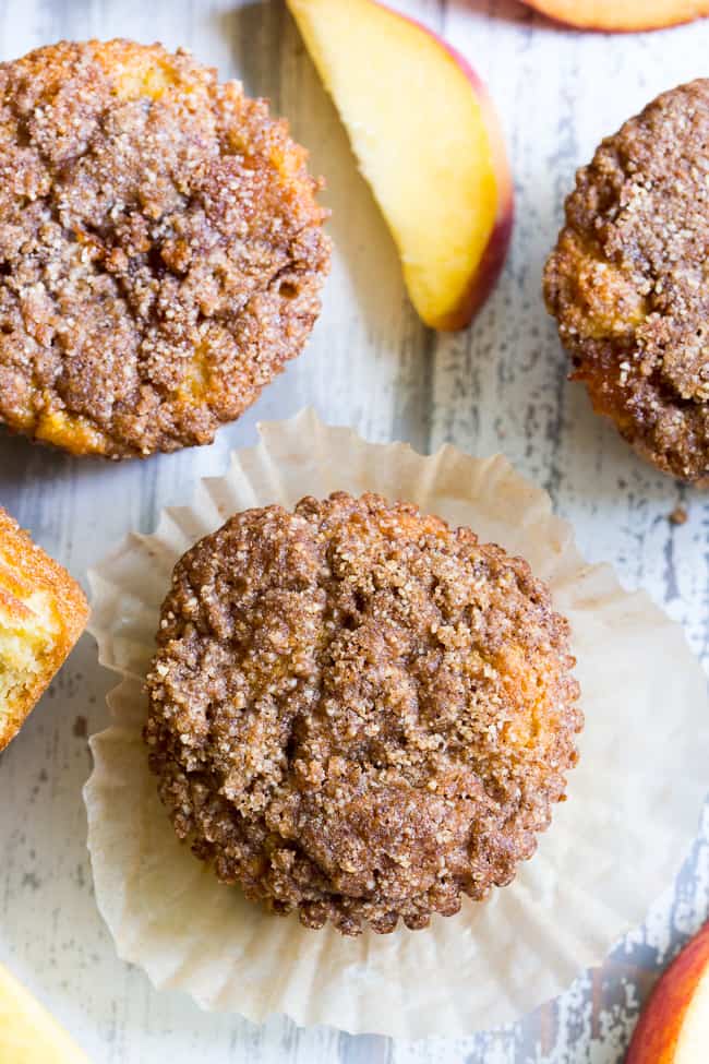 These Paleo peach muffins have double the peaches for tons of sweet summer flavor!  Easy peach preserves and chopped fresh peaches are mixed into a grain and dairy free muffin batter and topped with the perfect crumble.  Kid approved and great for summer snacking.