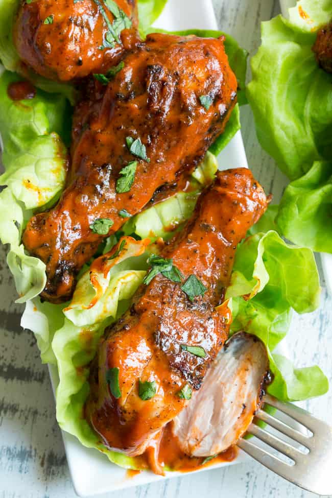 These spicy chicken drumsticks are perfectly seasoned, grilled, and tossed in a spicy, flavor-packed sauce!  Perfect for grilling season (or anytime of year!), family friendly, gluten-free, Paleo and Whole30 compliant. 