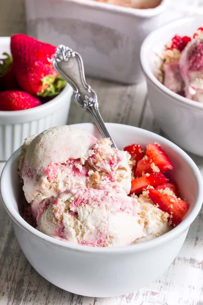 This Strawberry Cheesecake Paleo + Vegan Ice Cream begins with a cashew-based, creamy "cheesecake" ice cream and swirls in strawberry puree and a grain-free graham cracker crust!  It's the perfect special treat for summer that no one will guess is actually gluten-free, dairy free, paleo and vegan!