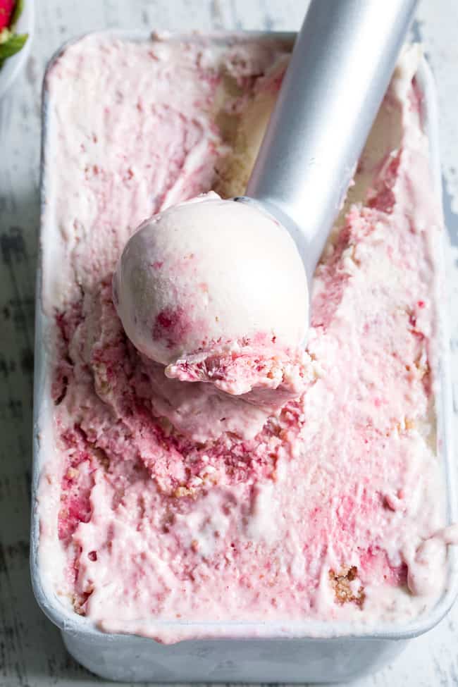 This Strawberry Cheesecake Paleo + Vegan Ice Cream begins with a cashew-based, creamy "cheesecake" ice cream and swirls in strawberry puree and a grain-free graham cracker crust!  It's the perfect special treat for summer that no one will guess is actually gluten-free, dairy free, paleo and vegan!