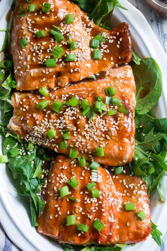 This Paleo and Whole30 Grilled Teriyaki Salmon is incredibly easy and busting out with flavor!  A simple date-sweetened teriyaki sauce is drizzled all over perfectly grilled salmon fillets and topped with toasted sesame seeds and scallions.  Perfect over a green salad or cauliflower rice!