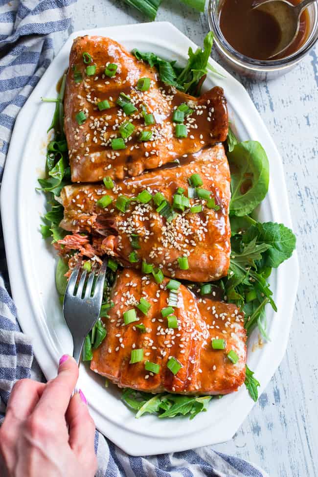 This Paleo and Whole30 Grilled Teriyaki Salmon is incredibly easy and busting out with flavor!  A simple date-sweetened teriyaki sauce is drizzled all over perfectly grilled salmon fillets and topped with toasted sesame seeds and scallions.  Perfect over a green salad or cauliflower rice!