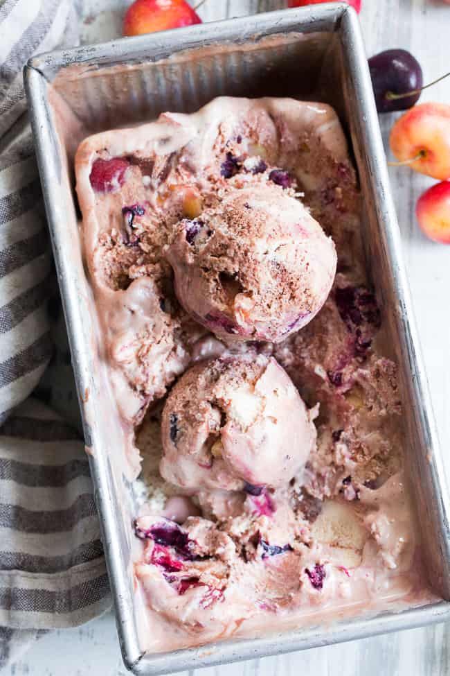 This cherry fudge swirl ice cream is made healthier, paleo, and vegan with coconut milk and pure maple sugar.  It's rich and creamy with a dreamy chocolate fudge swirl and lots of chopped fresh cherries in every bite.  Egg free, vegan, dairy free, refined sugar free and absolutely irresistible!