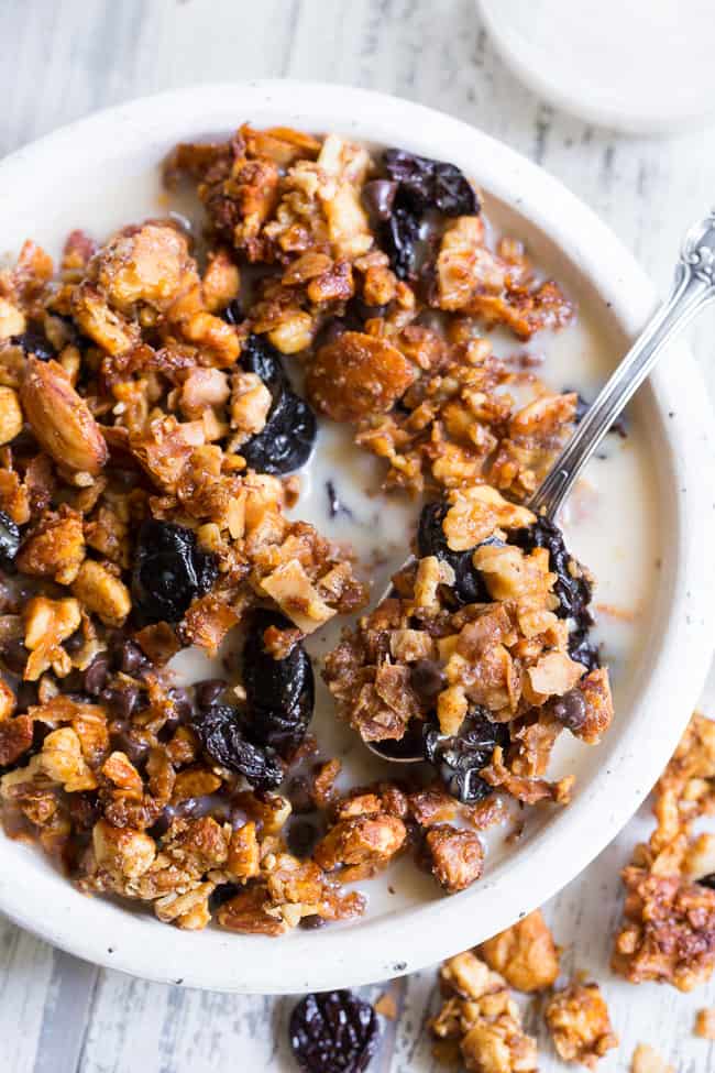 This crunchy paleo granola is loaded with goodies and so incredibly tasty!   Grain free granola clusters are baked with maple and tossed with sweet and tart dried cherries and dark chocolate chips.  It makes the perfect sweet snack or breakfast that everyone will love!  Gluten free, vegan, paleo.