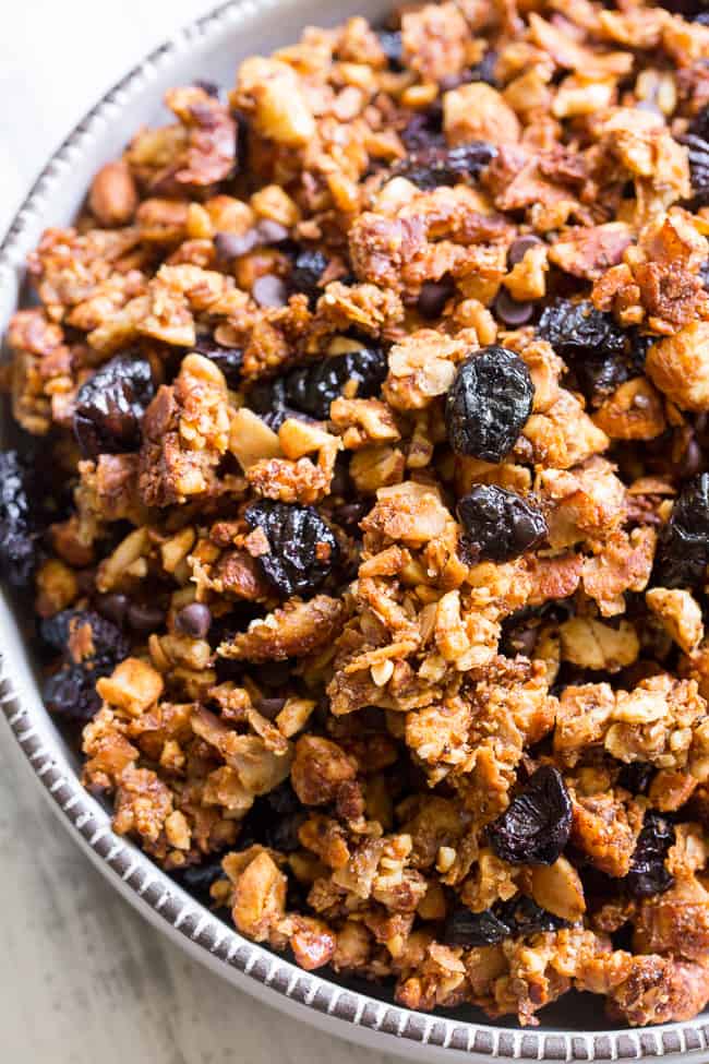 This crunchy paleo granola is loaded with goodies and so incredibly tasty!   Grain free granola clusters are baked with maple and tossed with sweet and tart dried cherries and dark chocolate chips.  It makes the perfect sweet snack or breakfast that everyone will love!  Gluten free, vegan, paleo.