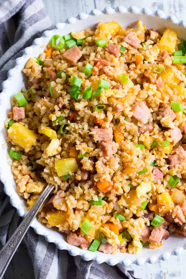 This Hawaiian Cauliflower Fried Rice is packed with goodies and so simple to make!  Chopped pineapples and sugar-free ham, peppers, onions and scrambled eggs make this "rice" a meal that you'll crave for busy weeknights.   It's also kid approved, low in carbs and Whole30 compliant!