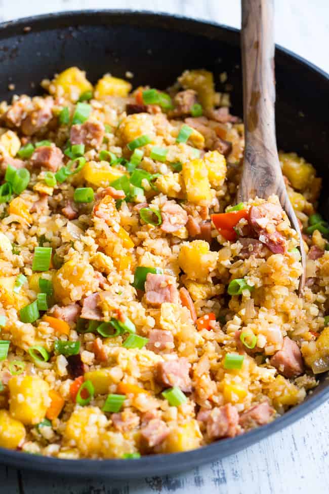 This Hawaiian Cauliflower Fried Rice is packed with goodies and so simple to make!  Chopped pineapples and sugar-free ham, peppers, onions and scrambled eggs make this "rice" a meal that you'll crave for busy weeknights.   It's also kid approved, low in carbs and Whole30 compliant!