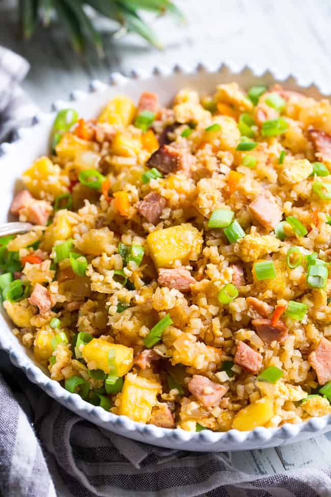 This Hawaiian Cauliflower Fried Rice is packed with goodies and so simple to make!  Chopped pineapples and sugar-free ham, peppers, onions and scrambled eggs make this "rice" a meal that you'll crave for busy weeknights.   It's also kid approved, low in carbs and Whole30 compliant!