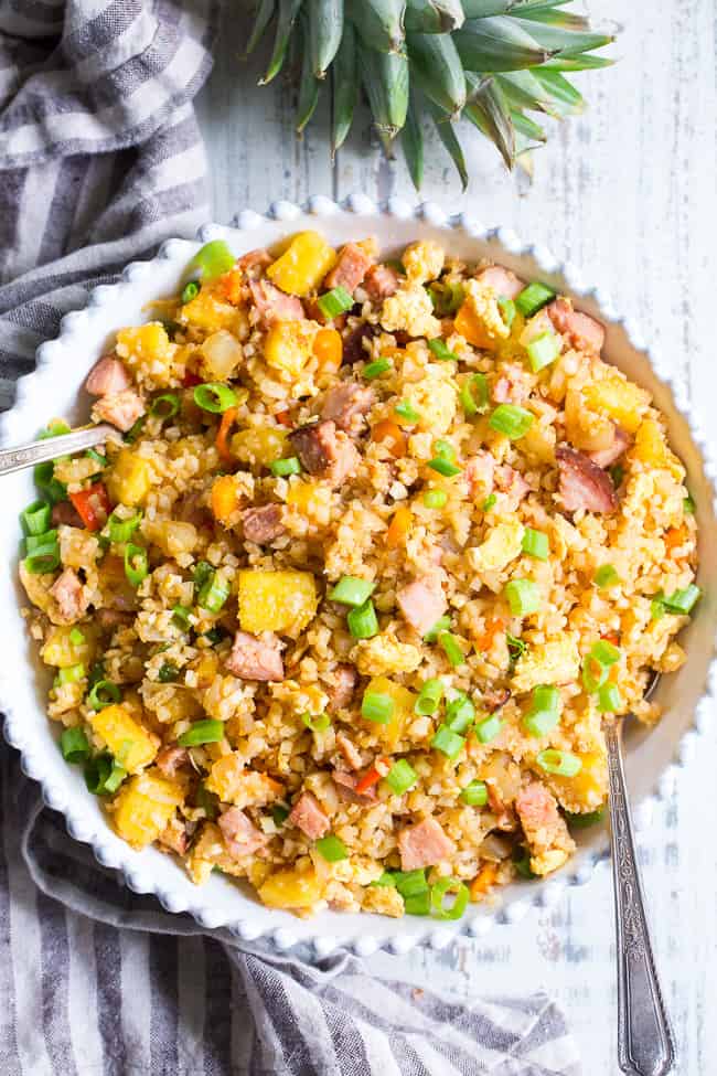 This Hawaiian Cauliflower Fried Rice is packed with goodies and so simple to make!  Chopped pineapples and sugar-free ham, peppers, onions and scrambled eggs make this "rice" a meal that you'll crave for busy weeknights.   It's also kid approved, low in carbs and Whole30 compliant!