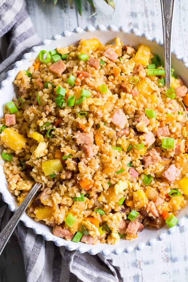 This Hawaiian Cauliflower Fried Rice is packed with goodies and so simple to make!  Chopped pineapples and sugar-free ham, peppers, onions and scrambled eggs make this "rice" a meal that you'll crave for busy weeknights.   It's also kid approved, low in carbs and Whole30 compliant!