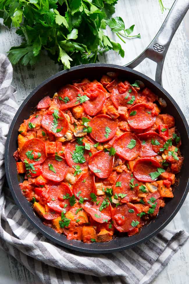 This sweet potato skillet is loaded up with all your favorite goodies just like a pepperoni pizza!  Pan-fried sweet potatoes with peppers, onions, mushrooms, pepperoni and pizza sauce make this paleo, gluten-free, dairy-free skillet quick, easy, and absolutely delicious!