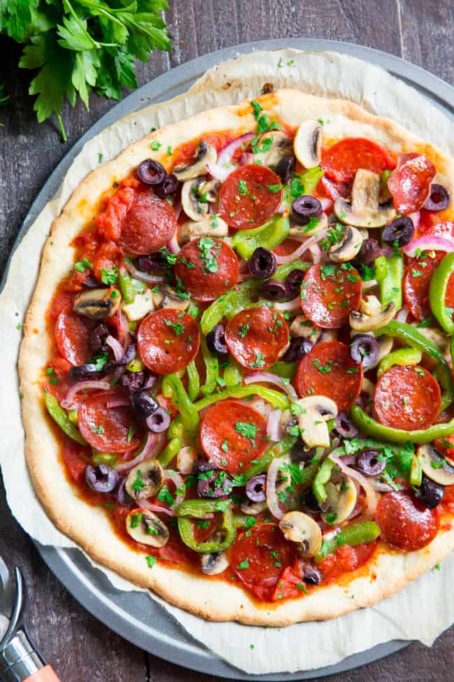 This paleo pepperoni pizza is loaded with all your favorite veggies and packed with flavor!  It's baked on the perfect paleo pizza crust and is totally dairy free, gluten free, grain free and soy free.  This healthy pizza is family approved and easy to make, too! 