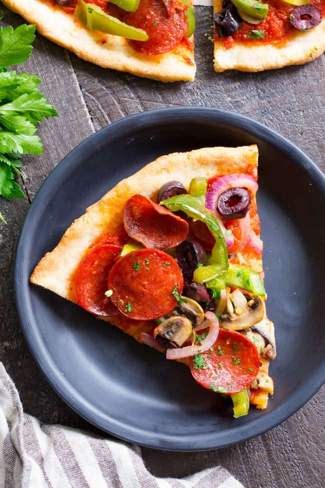 This paleo pepperoni pizza is loaded with all your favorite veggies and packed with flavor!  It's baked on the perfect paleo pizza crust and is totally dairy free, gluten free, grain free and soy free.  This healthy pizza is family approved and easy to make, too! 